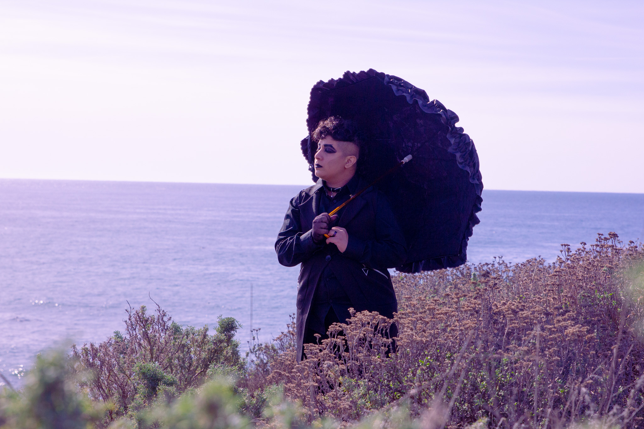 Me in all black, holding a lacy umbrella, walking along the seaside in Cambria