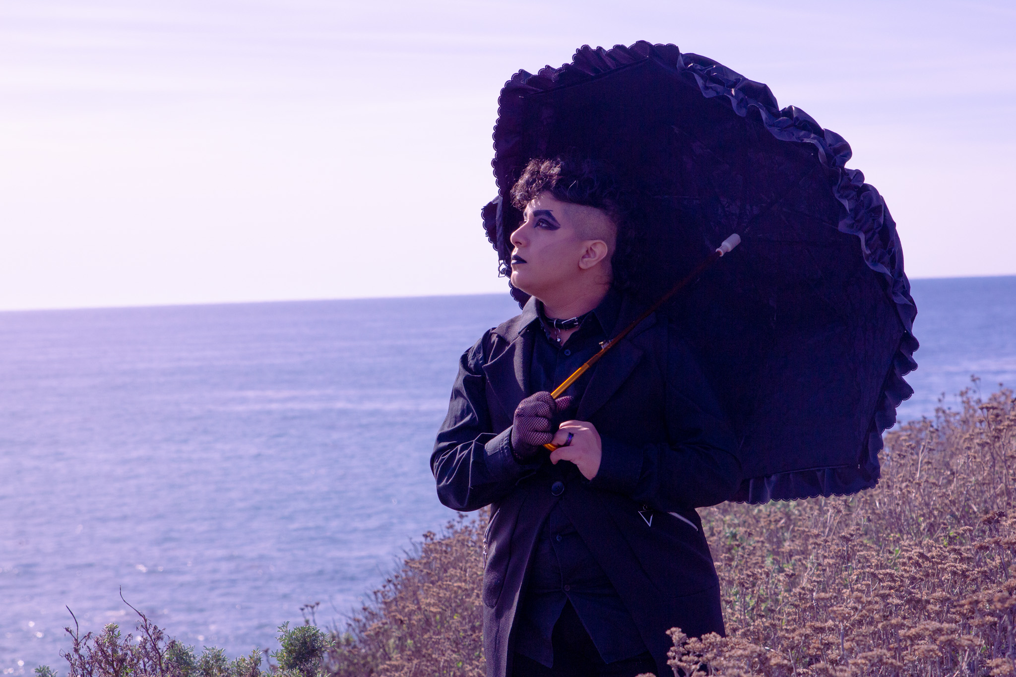 Me in all black, holding a lacy umbrella, observing the seaside in Cambria