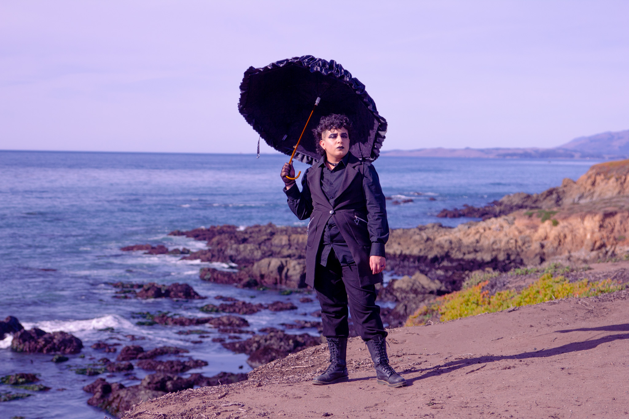 Me in all black, holding a lacy umbrella, posing amongst the seaside in Cambria