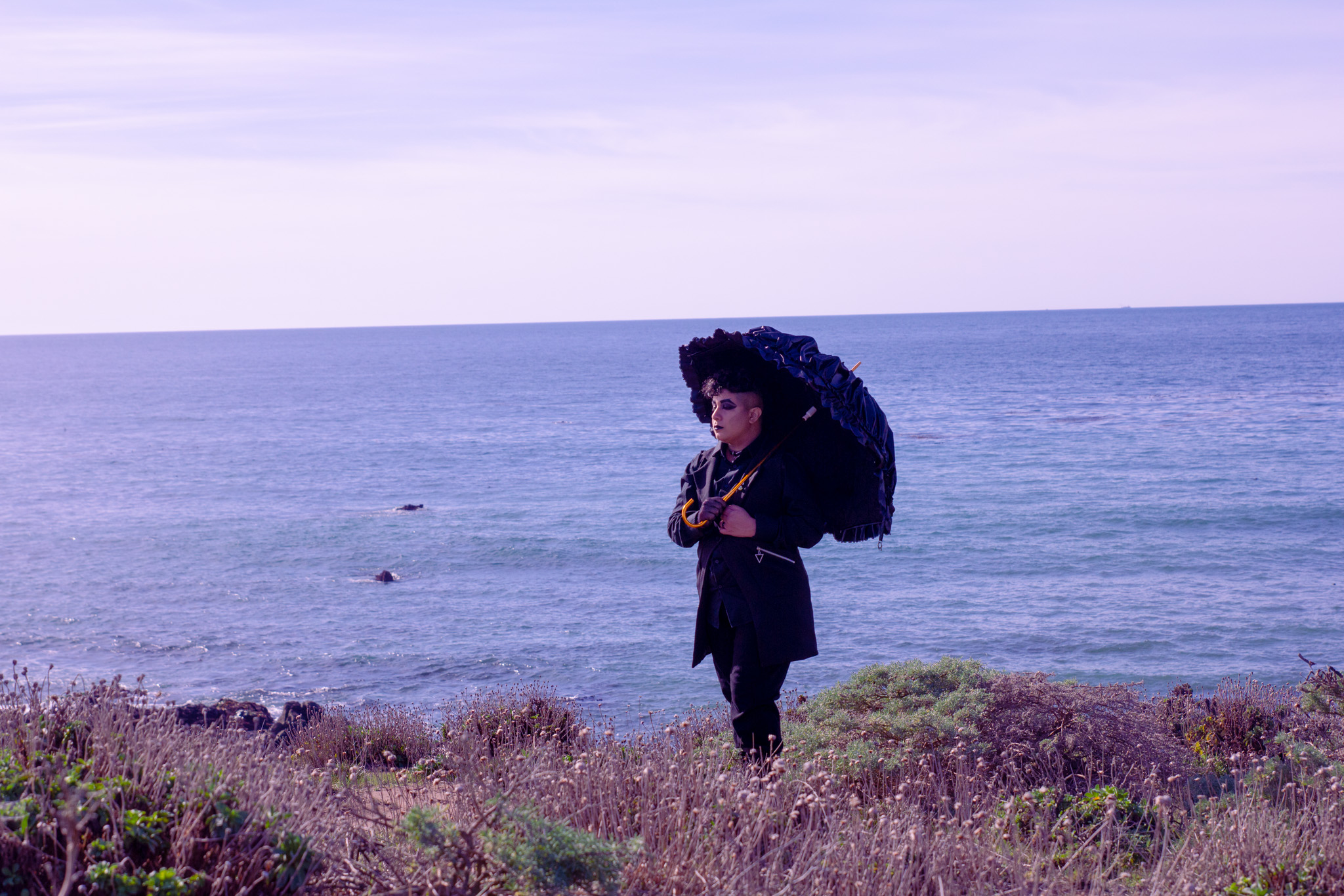 Me in all black, holding a lacy umbrella, strolling along the seaside in Cambria