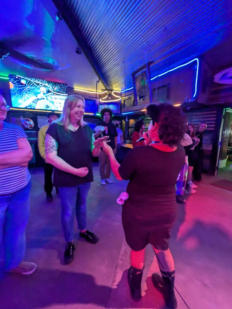 Me handing a pretty lady a flower while singing into a microphone. You can see more flowers in my pocket.